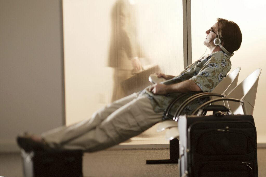 a person with sunglasses and headphones in an airport. HSP